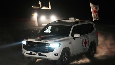 Red Cross convoy drives through Gaza at night carrying the bodies of three hostages for transfer to Israel.
