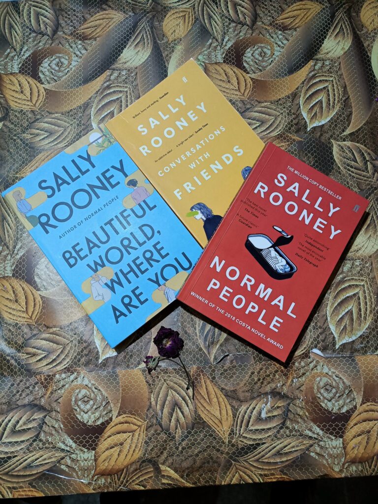 A collection of Sally Rooney novels titled "Beautiful World," "Conversations with Friends," and "Normal People.".