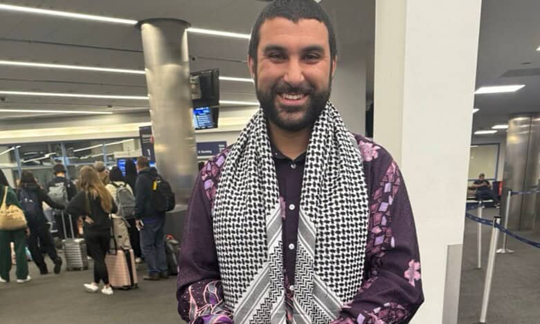 British-Tunisian journalist Sami Hamdi smiling at an airport terminal after his release from US immigration custody.