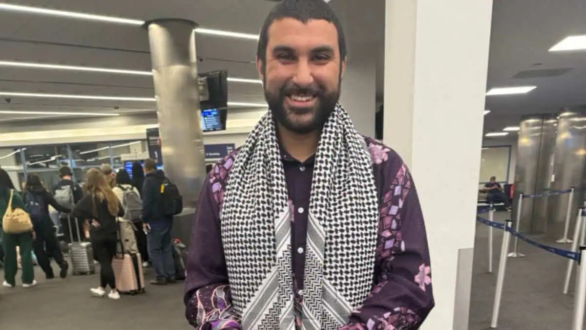 British-Tunisian journalist Sami Hamdi smiling at an airport terminal after his release from US immigration custody.