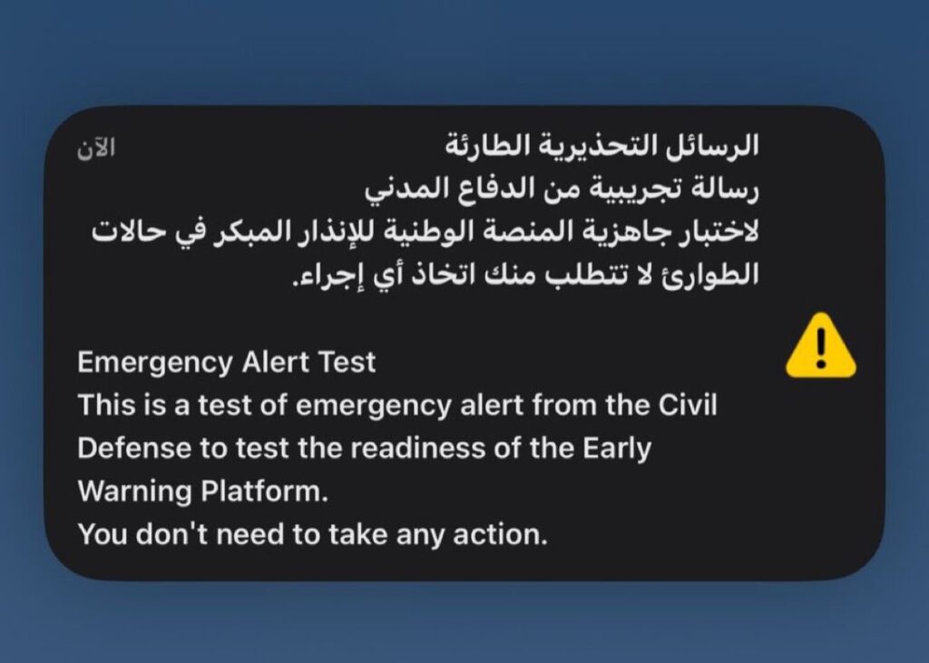 Emergency alert test message displayed on a mobile phone screen in Arabic and English, issued by Saudi Civil Defense.
