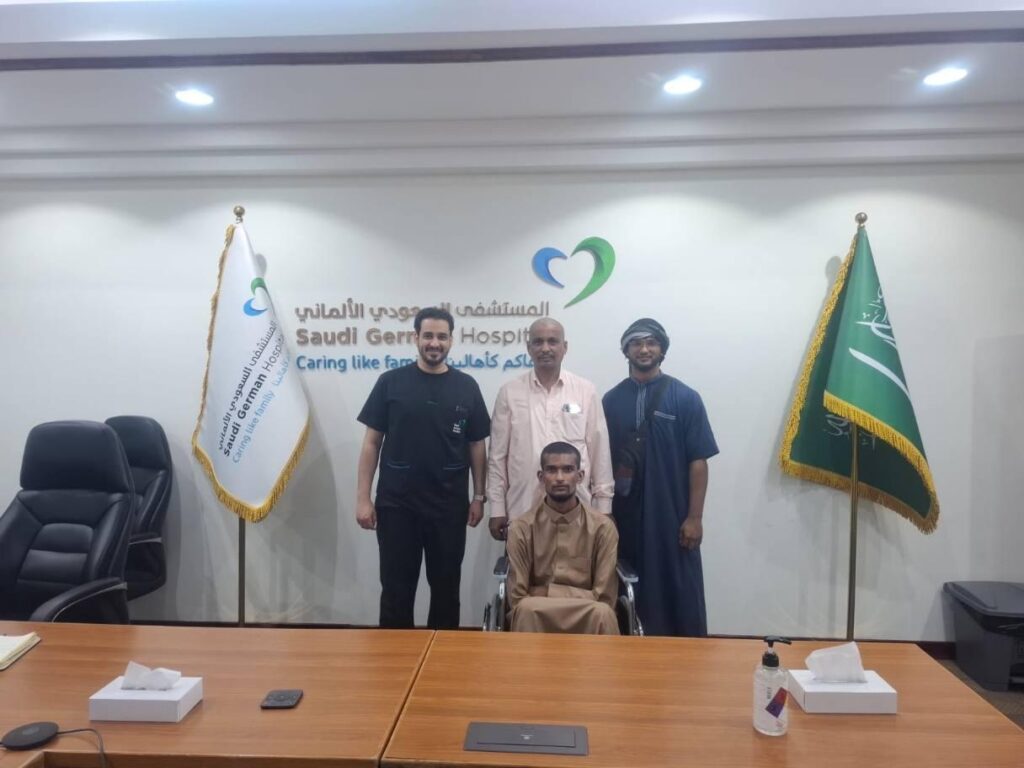 A man in a wheelchair at the Saudi German Hospital with staff and relatives.