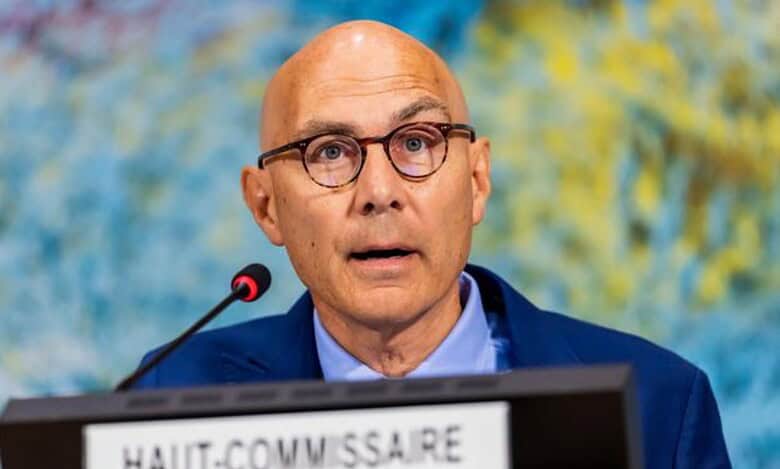 A UN human rights official speaking at a podium with a microphone.