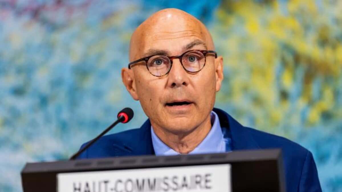 A UN human rights official speaking at a podium with a microphone.