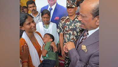 Yusuff Ali speaks with a mother holding her bedridden son during a visit to Kollam, Kerala, offering assistance for the child’s treatment.