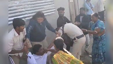 Image shows a man hitting a police man with a rock in Telangana's Adilabad.