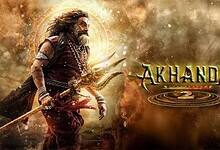 Movie poster for 'Akhanda 2' featuring a warrior with long hair and beard in traditional attire, holding a trident against a dramatic golden and dusty background with mystical circular symbols