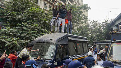 Members of West Bengal Hindu Jagran stand on top of a police van as police personnel detain other agitators during a protest against the killing of a Hindu youth in Bangladesh near the Bangladesh Deputy High Commission in Kolkata on Tuesday. (PTI Photo/Manvender Vashist Lav)