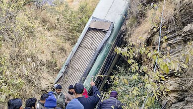 Almora: People gather around a damaged bus which fell-off a deep gorge, in Almora district.
