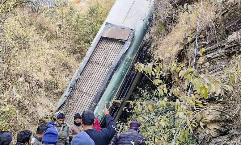Almora: People gather around a damaged bus which fell-off a deep gorge, in Almora district.