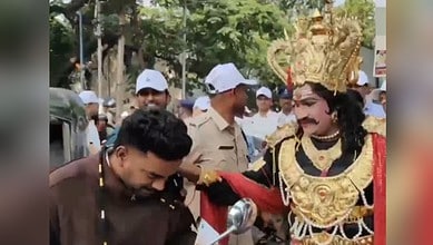 Image shows a man dressed at Yamraj handing garlanding a man