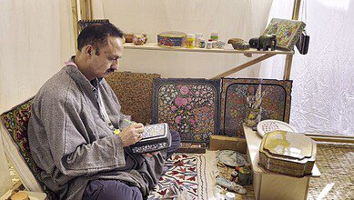 Artist Maqbool Jan paints on a papier mache box at the '10th Serendipity Arts Festival', in Panaji, Goa. (PTI Photo/Manish Sain)