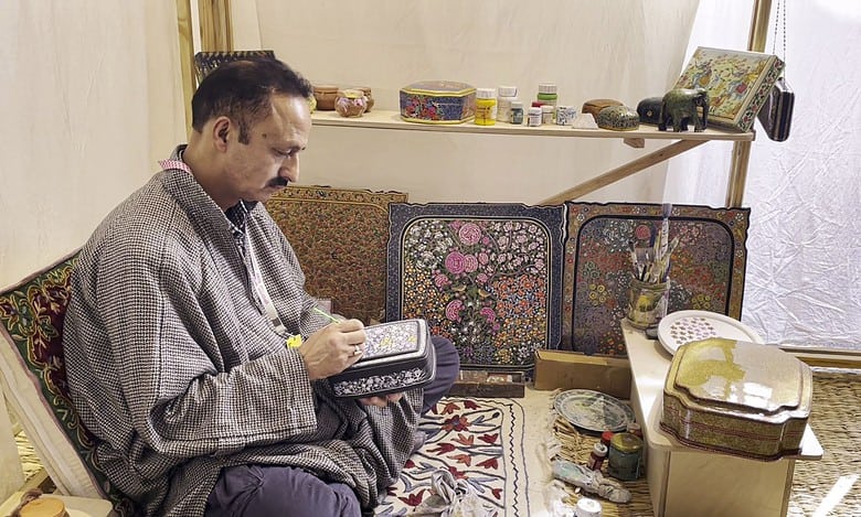 Artist Maqbool Jan paints on a papier mache box at the '10th Serendipity Arts Festival', in Panaji, Goa. (PTI Photo/Manish Sain)