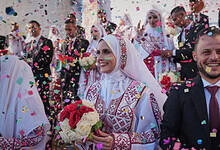 Palestinian couples participate in a mass wedding ceremony in Hamad City in Khan Younis, Gaza Strip