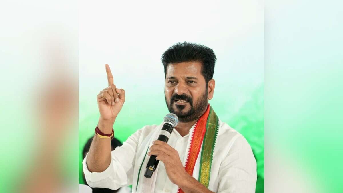 Image shows Telangana Chief Minister Revanth Reddy holding a mic