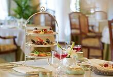 Elegant afternoon tea service with three-tiered stand, fine china, and colorful beverages at Taj Falaknuma Palace, Hyderabad
