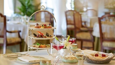 Elegant afternoon tea service with three-tiered stand, fine china, and colorful beverages at Taj Falaknuma Palace, Hyderabad