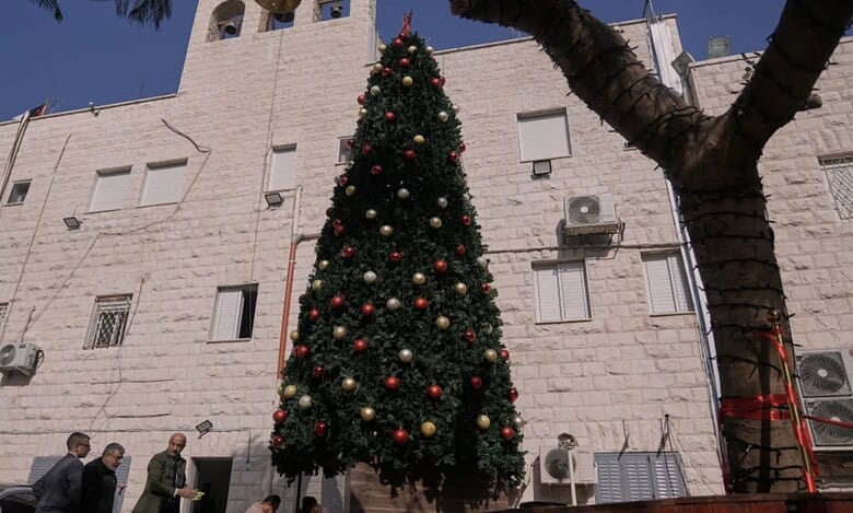 Palestinian parishioners check a recently installed Christmas tree after the previous one was destroyed at the Holy Redeemer Latin Church in the West Bank town of Jenin, Tuesday, Dec. 23, 2025. (AP Photo/Majdi Mohammed)