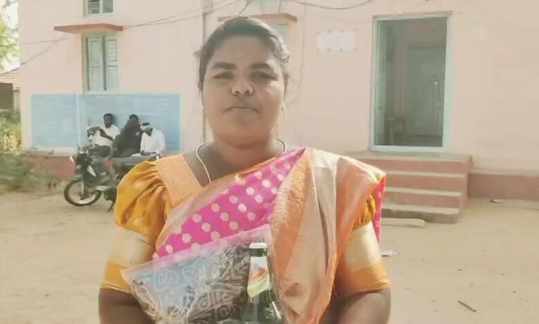 A woman returns beer and saree given by a losing candidate in Telangana