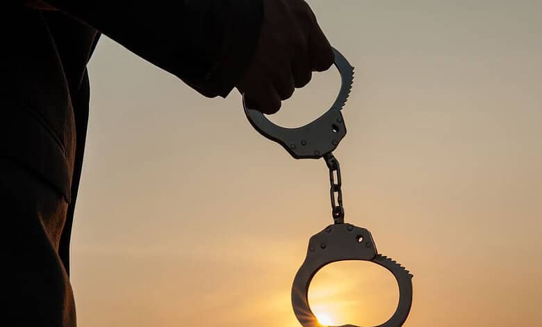 A person holding a handcuff.