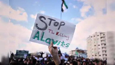Protesters hold placards during Alawite demonstration in Latakia.