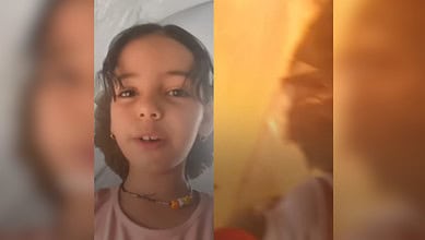 A girl records a video in her tent in Gaza