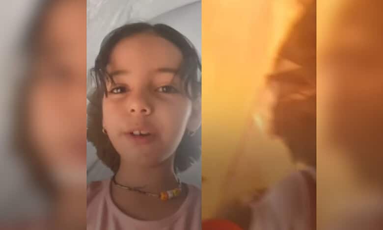A girl records a video in her tent in Gaza
