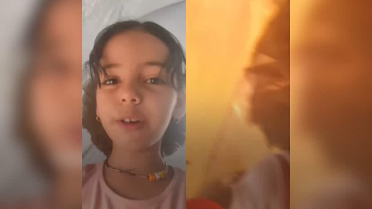 A girl records a video in her tent in Gaza