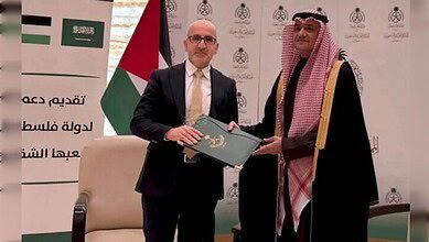 Estephan Salameh and Prince Mansour bin Khalid exchange documents during a ceremony in Amman.