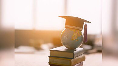 Image showing a globe sitting on top of a pile of books with a graduation hat on top of the globe
