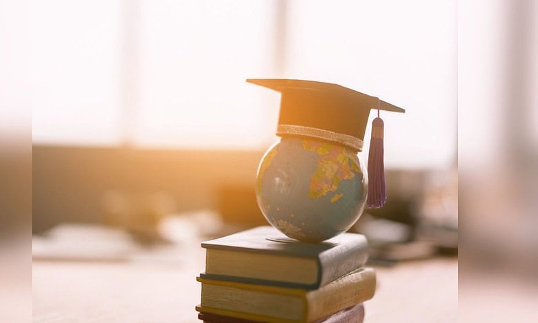 Image showing a globe sitting on top of a pile of books with a graduation hat on top of the globe