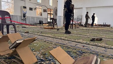 Armed men stand inside the Imam Ali ibn Abi Talib Mosque following an explosion in the Wadi al-Dahab neighbourhood of Homs, Syria, December 26 [Omar Haj Kadour/AFP]