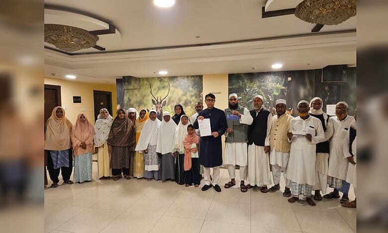 Pilgrims standing together in a hotel lobby holding flight papers.