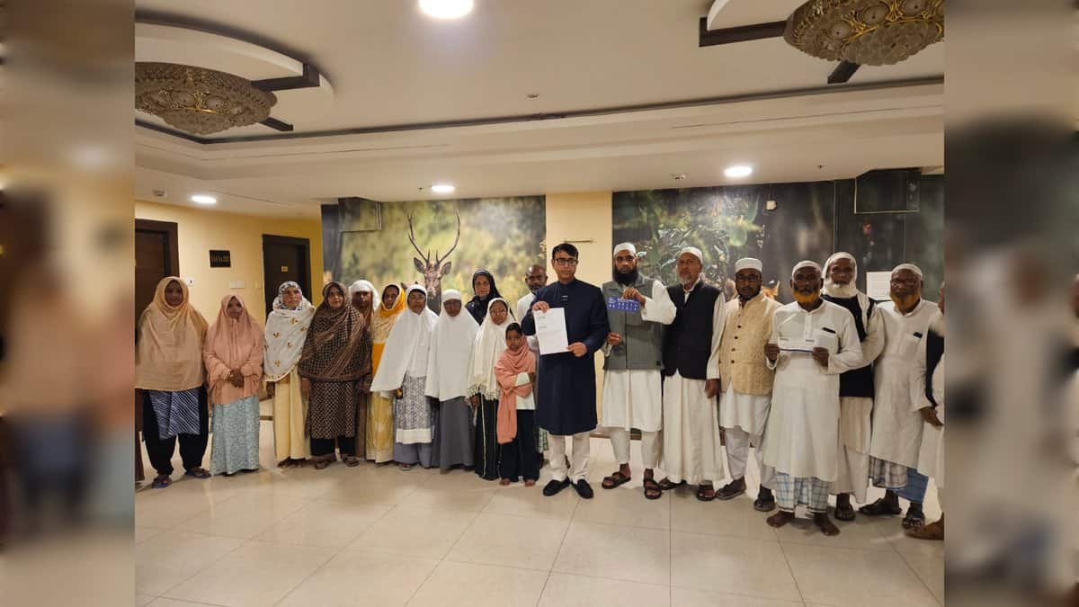 Pilgrims standing together in a hotel lobby holding flight papers.