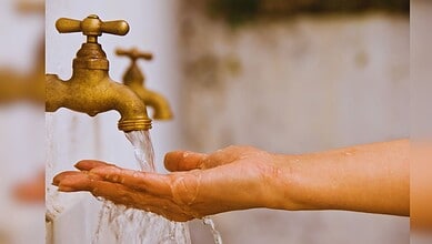 Hand washing under running water from a brass faucet