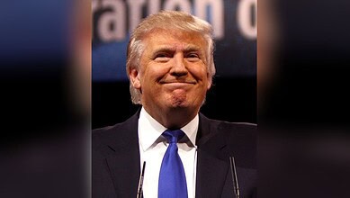 Republican leader Donald Trump with a confident smile at a political rally.