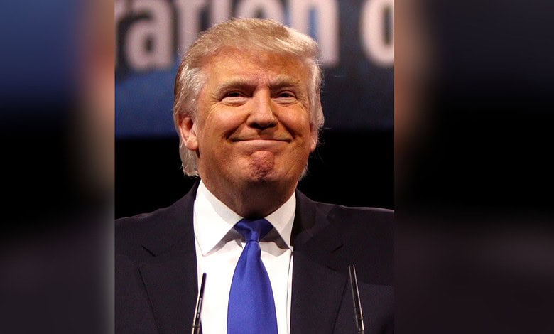 Republican leader Donald Trump with a confident smile at a political rally.