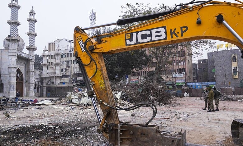 An excavator used in demolition of alleged encroachments stands amid rubble after the demolition of alleged encroachments on land adjoining the mosque, carried out by the Municipal Corporation of Delhi