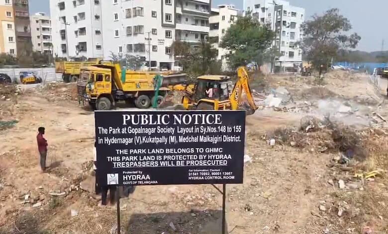 Image shows Public notice sign by HYDRAA at cleared construction site with apartments and heavy machinery in background