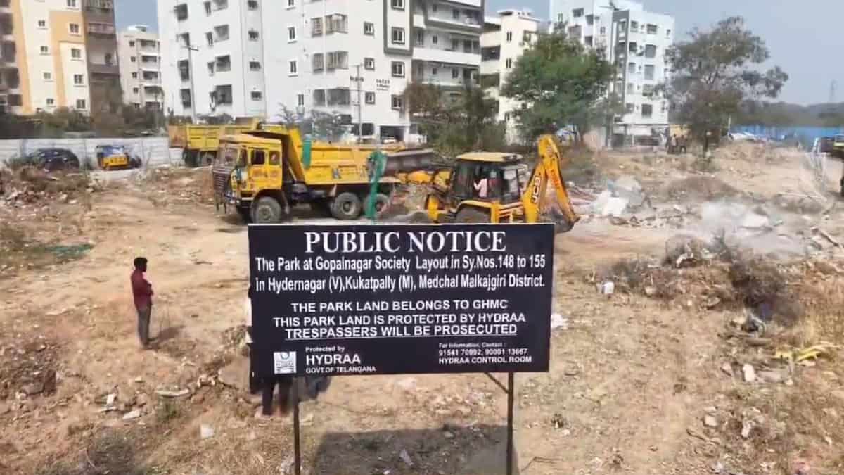 Image shows Public notice sign by HYDRAA at cleared construction site with apartments and heavy machinery in background