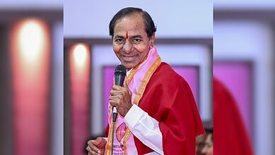 A man in traditional attire holding a microphone at an event.
