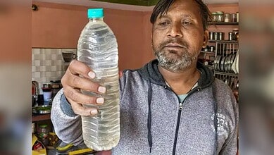 A person shows a bottle of contaminated drinking water in Indore, Madhya Pradesh