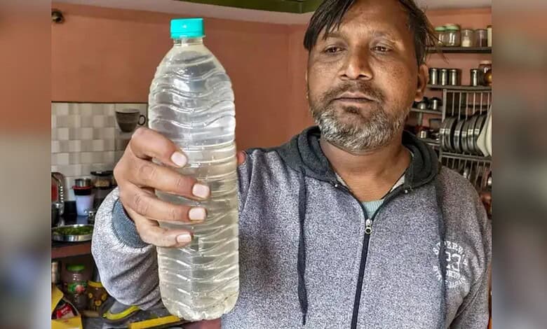A person shows a bottle of contaminated drinking water in Indore, Madhya Pradesh