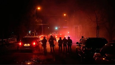 Tear gas surrounds federal law enforcement officers as they leave a scene after a shooting on Wednesday, Jan. 14, 2026, in Minneapolis. (AP Photo/John Locher)