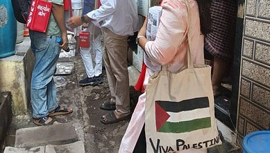 A supporter of RWI candidate carries a bad with a Palestinian flag artwork