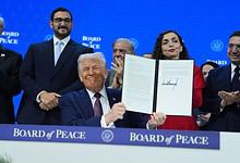 President Donald Trump, center, holds up a signed Board of Peace charter during the Annual Meeting of the World Economic Forum in Davos, Switzerland, Thursday, Jan. 22, 2026. AP/PTI