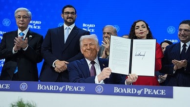 President Donald Trump, center, holds up a signed Board of Peace charter during the Annual Meeting of the World Economic Forum in Davos, Switzerland, Thursday, Jan. 22, 2026. AP/PTI