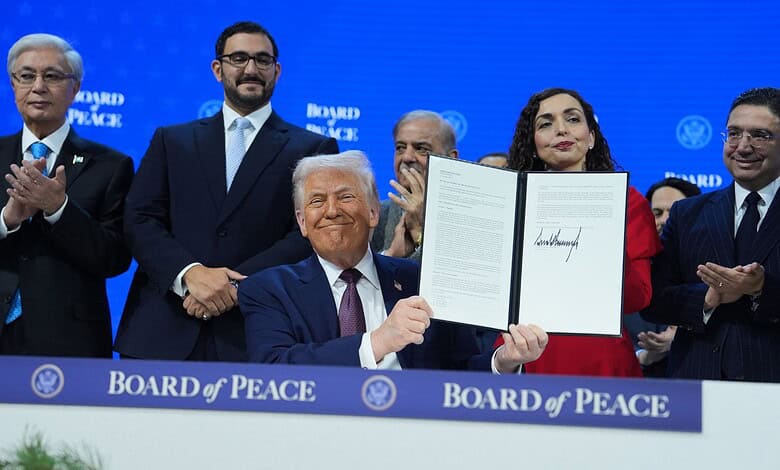 President Donald Trump, center, holds up a signed Board of Peace charter during the Annual Meeting of the World Economic Forum in Davos, Switzerland, Thursday, Jan. 22, 2026. AP/PTI
