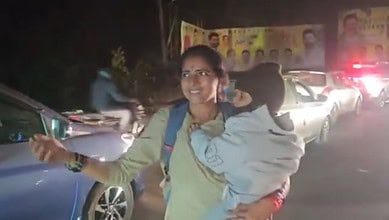 A woman constable directs traffic in Andhra Pradesh with her child in arms