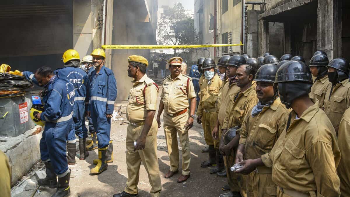 Police personnal and firefighters during a cooling and rescue operation after a fire broke out in a four-storey furniture shop building on Saturday, at Nampally, in Hyderabad -